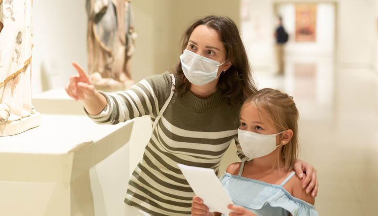 Mother and daughter wearing masks in a museum