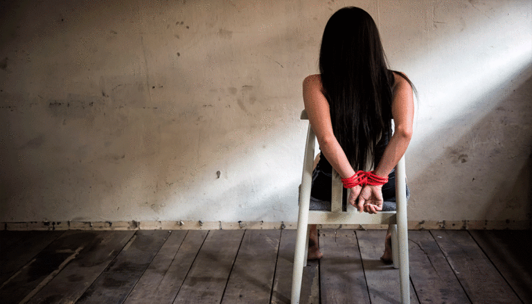 Woman-sitting-in-chair-with-hands-bound-by-rope