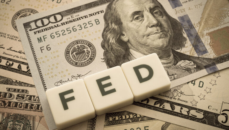 Pile of money with FED spelled in scrabble tiles