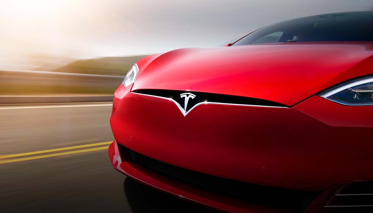 Toronto, Ontario / Canada - November 22nd 2019 : Photograph of a red Tesla model S driving on the road, close up on the front.