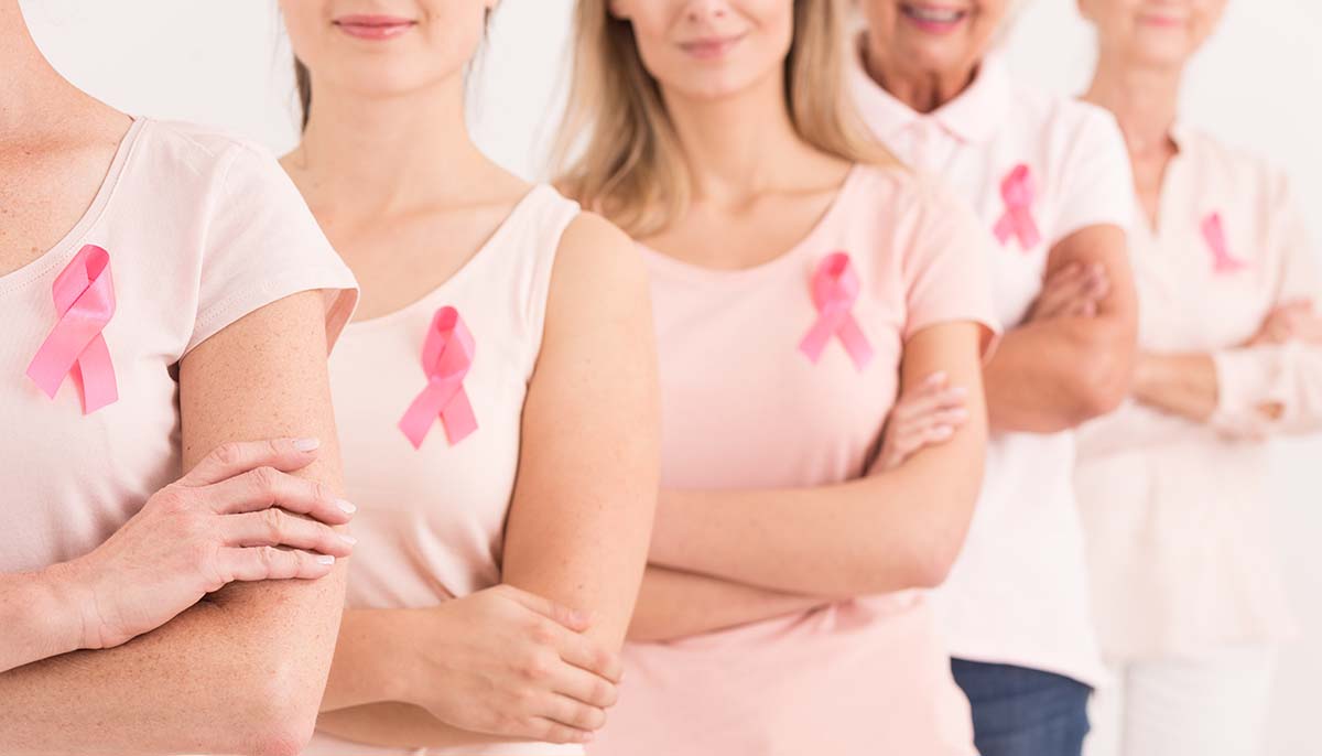 The power to fight breast cancer, women wearing pink ribbons for breast cancer campaign on white background