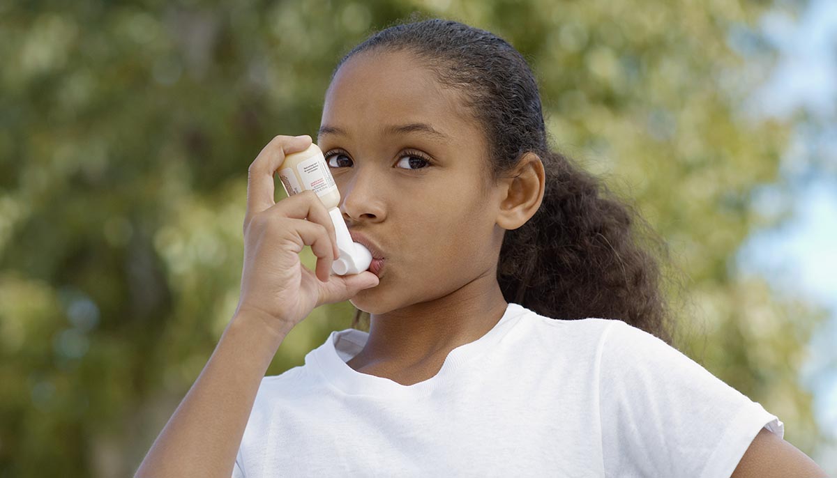 Portrait of a girl using asthma inhaler